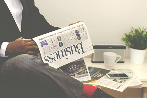 man reading business section of newspaper