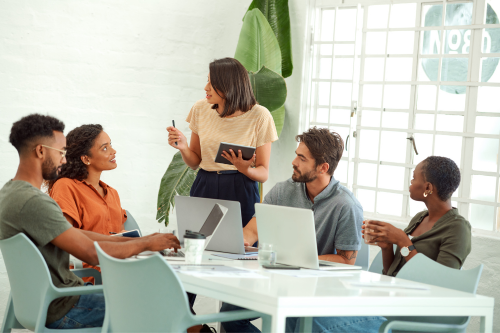 The image shows a diverse group of five people in a modern office or meeting room.