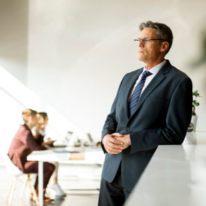 COO standing thinking about team